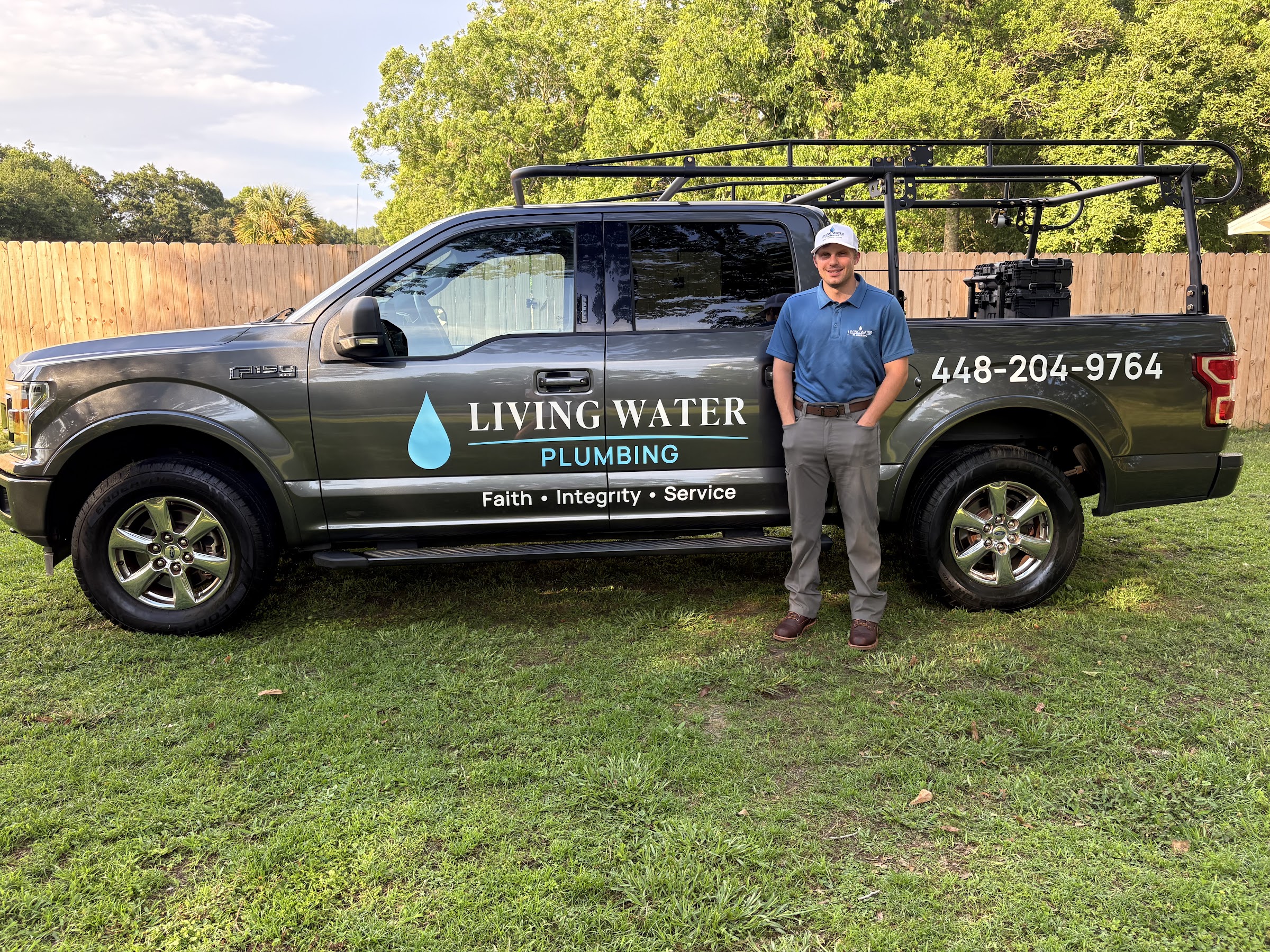 Logan Omtvedt with the Living Water Plumbing service truck in Pensacola, FL